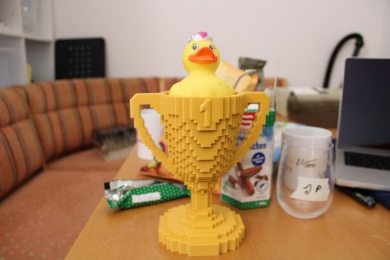 Picture of a 3D printed trophy in a low-poly style with a duck sitting inside the trophy.